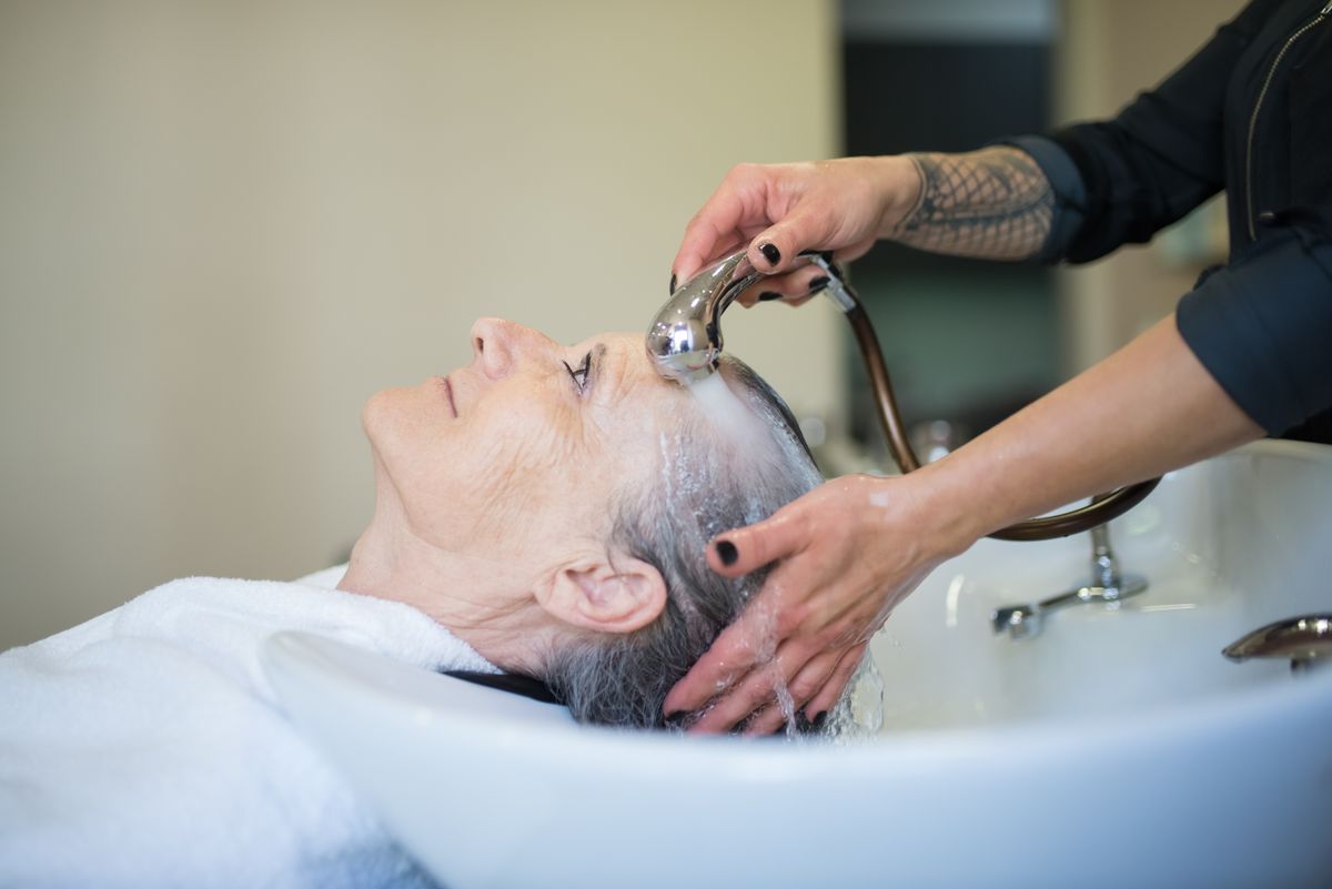Lavagem de cabelo com água corrente, fios molhados e escorridos
